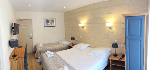 a hotel room with two beds and a blue door at Hôtel Cristol in Briançon