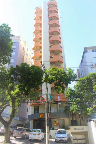 a tall building with cars parked in front of it at Rio Branco Hotel in Florianópolis