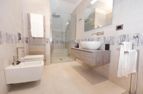 a white bathroom with a sink and a toilet at Corte Maggiore in Ravenna