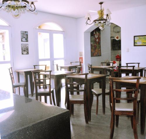 comedor con mesas, sillas y espejo en Crigial Hotel, en Jaguarão