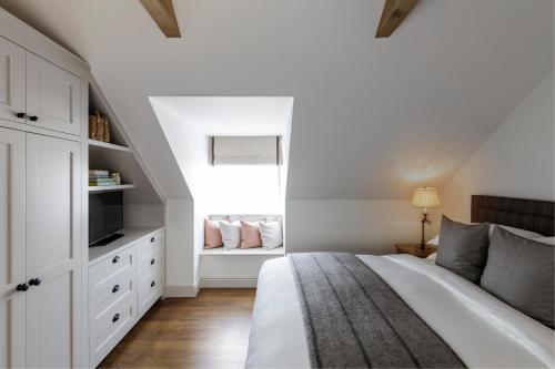 a white bedroom with a bed and a window at Hurley House Hotel in Hurley