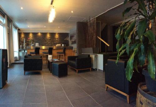 a lobby with chairs and tables in a building at Hôtel Cristol in Briançon