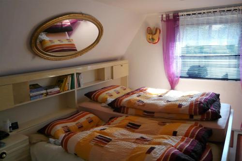 two beds in a small room with a mirror at Haus Marta in Smržovka