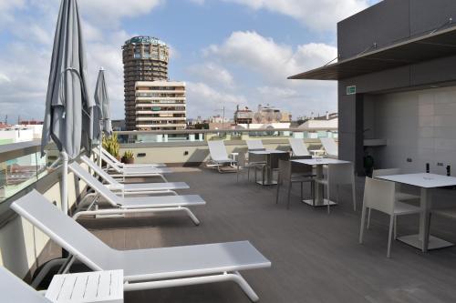 a balcony with white chairs and tables on a building at TC Hotel Doña Luisa in Las Palmas de Gran Canaria