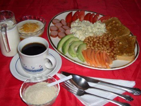 a table with a plate of food and a cup of coffee at Coastgate Hotel in Mombasa