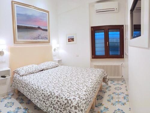 ナポリにあるMini Appartamento Al Chiostroの白いベッドルーム(ベッド1台、窓付)