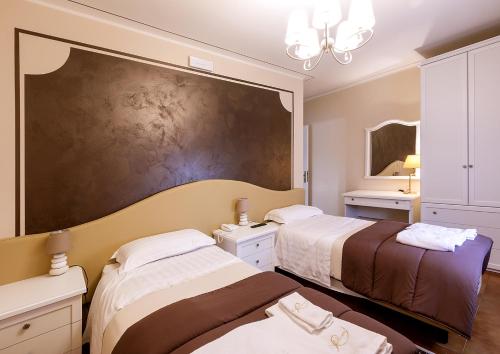 a bedroom with two beds and a large painting on the wall at Il Novecento in Casarsa della Delizia
