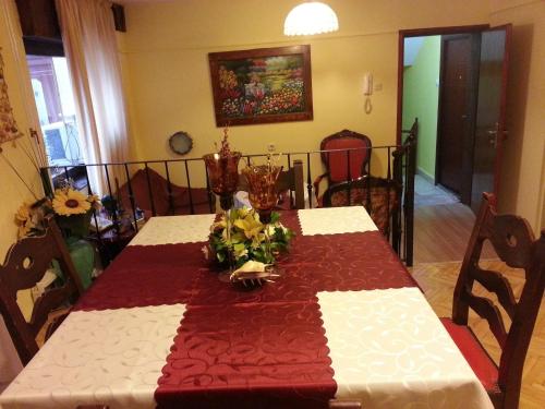 a dining room table with a red and white table cloth at Hotel Kapistec Skopje in Skopje