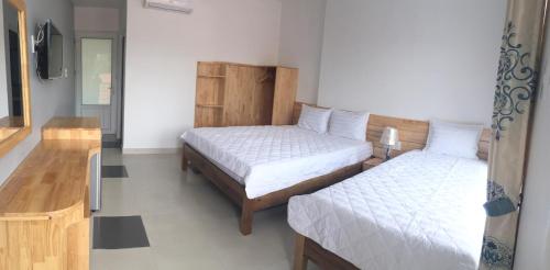 a bedroom with two beds and a television in it at MAY Bungalow in Mui Ne