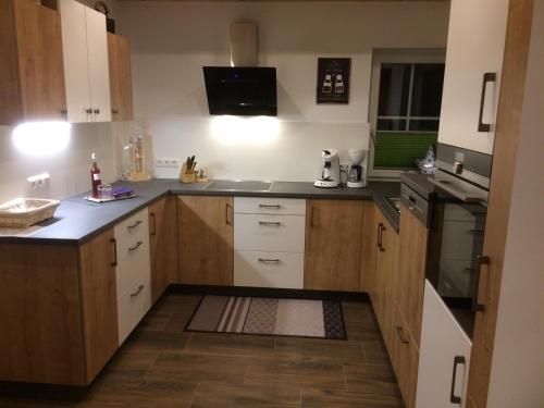 a kitchen with wooden cabinets and white appliances at Ferienhaus Wind in Sankt Margarethen im Lungau