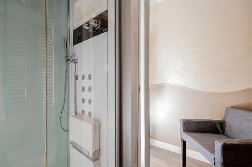 a bathroom with a shower and a chair in a room at Demetra Hotel in Rome