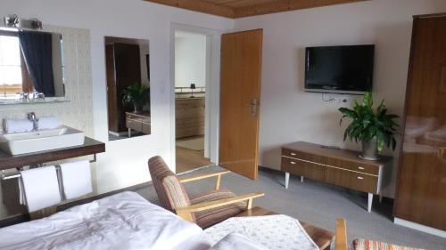 a bedroom with a bed and a sink and a tv at Haus Rosi in Uttendorf