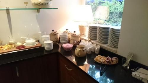 a kitchen with a counter with plates and dishes at Hotel Arena City in Leipzig