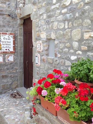 a stone building with flowers in front of a door at Mini Appartamenti Nonna Nella in Barbarasco