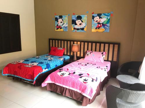 una camera con due letti e lenzuola di Hello Kitty di Gold Coast Morib Mickey House a Banting