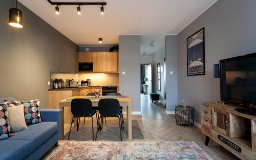 a living room and kitchen with a blue couch and a table at GRANO APARTMENTS Gdańsk Motława SPA & Wellness in Gdańsk