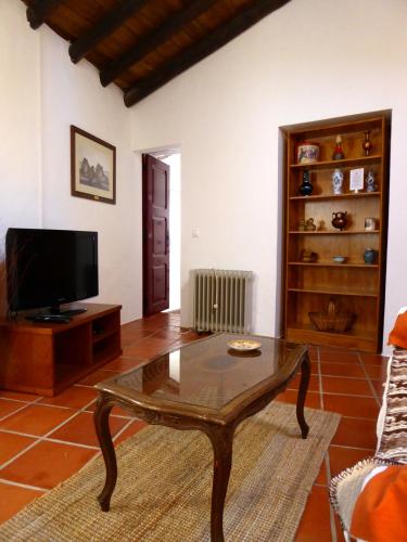 a living room with a coffee table and a tv at Monte do Laranjal in Monsaraz
