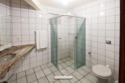 a bathroom with a shower with a toilet and a sink at Oscar Hotel in Florianópolis