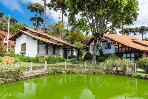 a house with a pond in front of it at Vila Suzana Parque Hotel in Canela