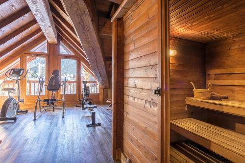 a gym with exercise equipment in a wooden building at Hotel Kandahar in Val dʼIsère