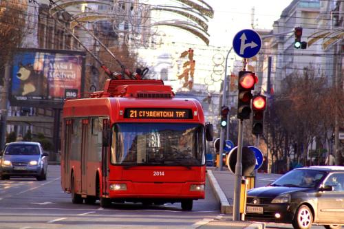 a red bus driving down a city street with cars at Dominic Smart & Luxury Suites - Terazije in Belgrade