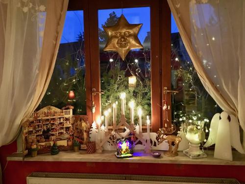 a window with lit candles and a christmas tree at Côté vignes in Marlenheim