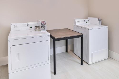 a laundry room with a table and a washer and dryer at Palace Inn Blue Tomball Parkway in Houston