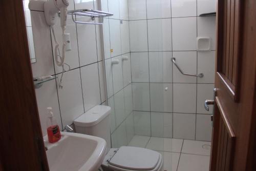 a bathroom with a shower and a toilet and a sink at Hotel Sandis Mirante in Santarém