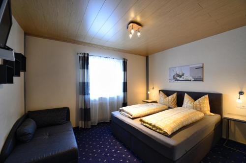 Un dormitorio con una cama y un sofá y una ventana. en Appartements Sigmair, en Valdaora