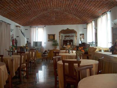 a dining room with tables and chairs and a large ceiling at Albergo Antica Dogana in Asti