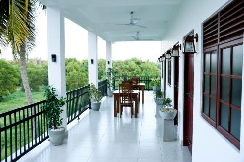 a balcony with a table and chairs and plants at Otha Shy Airport Transit Hotel in Katunayake