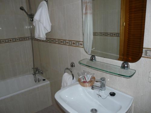 a bathroom with a sink and a mirror and a tub at Hotel Santa María in Palos de la Frontera