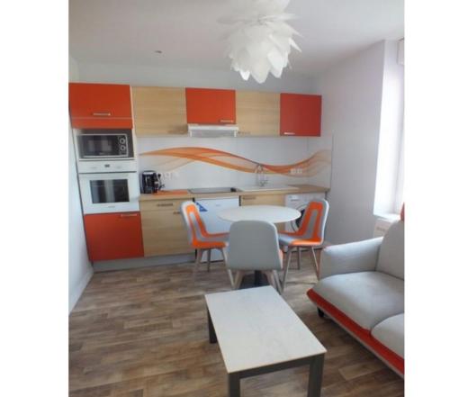 a kitchen and dining room with a table and a couch at Residence Miranto in Châteauroux