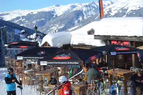 a group of people standing in front of tables and umbrellas at Le Solan d'Aniathazze in Peisey-Nancroix
