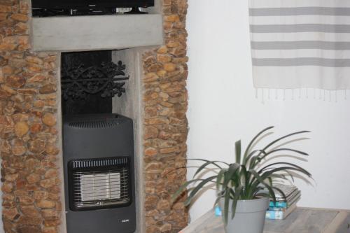 a stone fireplace in a room with a plant at Ashbourne Country Escape Hazyview in Hazyview