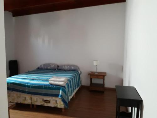 a bedroom with a bed and a table with a lamp at Apartamento La Plata in La Plata
