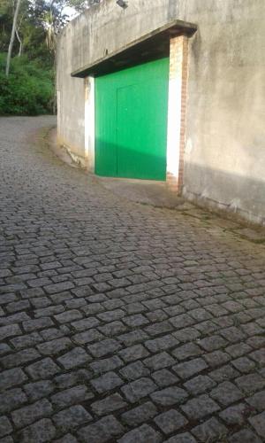 a green door on the side of a building at Sítio N#1 da Serra Perfeito para famílias com bebês e crianças Piscina aquecida e limpeza incluídos in Teresópolis
