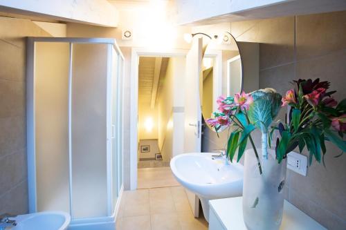 baño con lavabo y jarrón de flores en Lenno Terraze Speso, en Lenno