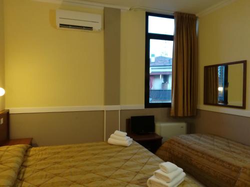 um quarto de hotel com duas camas e uma janela em Hotel Marco Polo SELF CHECK-IN em Bolonha