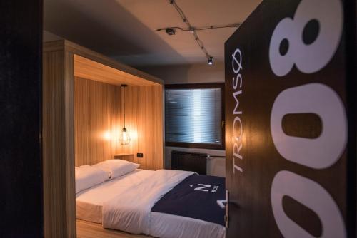 a bedroom with a bed and a sign in the doorway at Nordic Hostel N-Box in Skopje