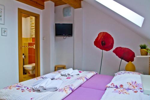 Un dormitorio con una cama con flores rojas. en Pension Art en Lázně Bohdaneč