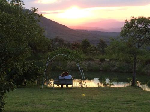 a couple sitting on a bench in front of a lake at Ashbourne Country Escape Hazyview in Hazyview