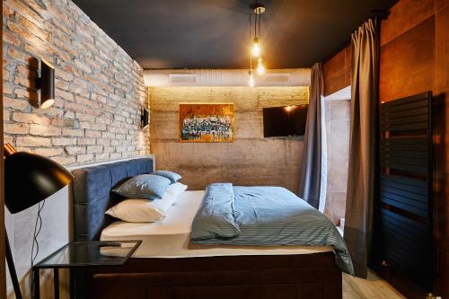 a bedroom with a bed and a brick wall at Apartment and Rooms Marinac in Zagreb