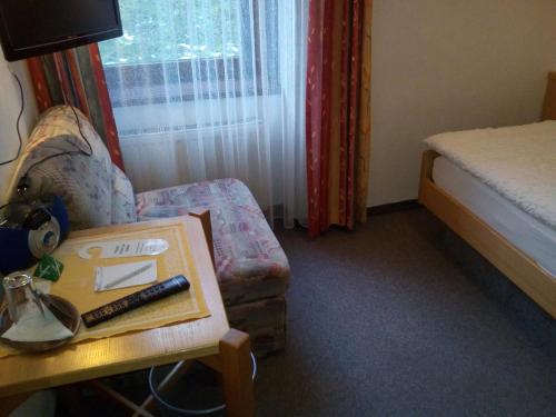a room with a bed and a chair and a table at Hotel zum goldenen Hirschen in Göstling an der Ybbs