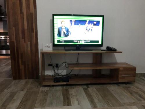 a flat screen tv sitting on a wooden stand at Kays Residence in Pereybere