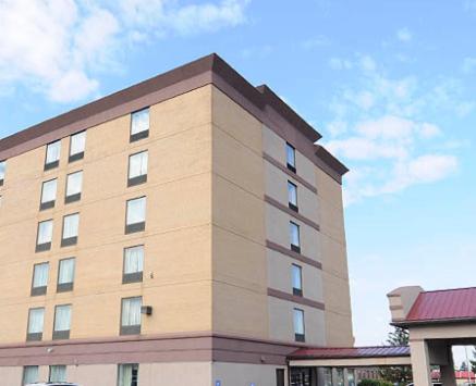 a tall brick building with a sky in the background at Days Inn by Wyndham Calumet Park in Calumet Park