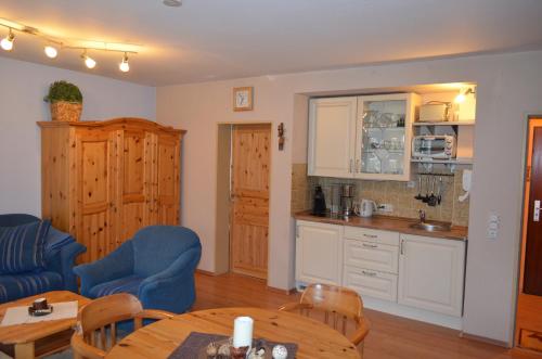 a kitchen and a living room with a table and chairs at Fewo Kuhlmann in Willingen