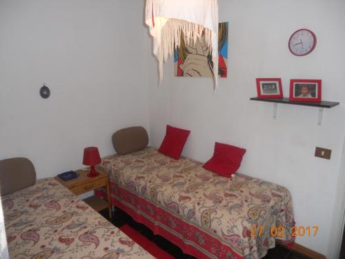 パレルモにあるVilletta Abbateのベッドルーム1室(ベッド2台、壁掛け時計付)