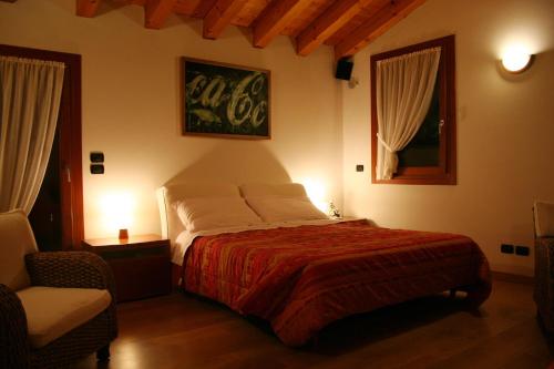 a bedroom with a large bed and a chair at VillaRosa in Santa Lucia di Piave