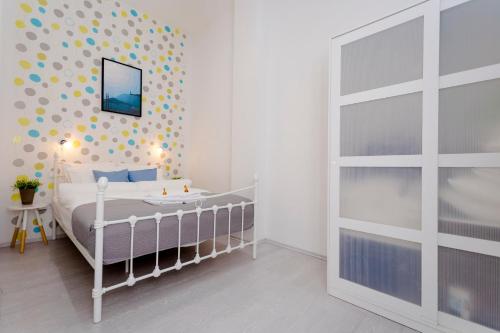 a bedroom with a white bed and a polka dot wall at Boutique Residence Jokai - Apartment in the city center in Budapest